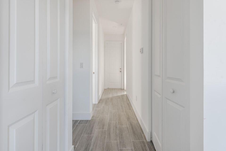 A hallway with white doors, light gray wood-look tile flooring, and recessed ceiling lighting — 260 Rotonda Boulevard # 2, FL 33947, FL