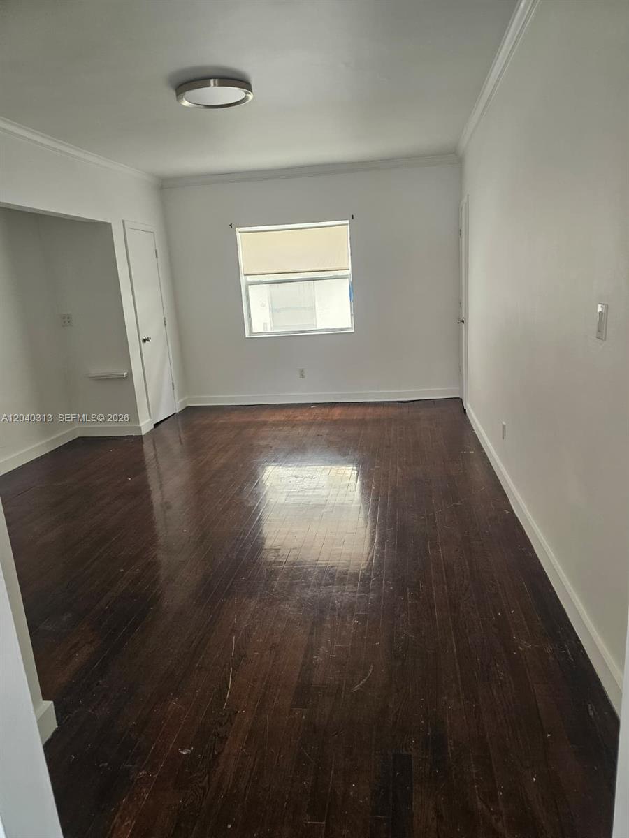 An empty room features dark hardwood floors, white walls, and a single window — 1614 Jefferson Ave # 3, Miami Beach FL 33139, MIAMI BEACH, FL