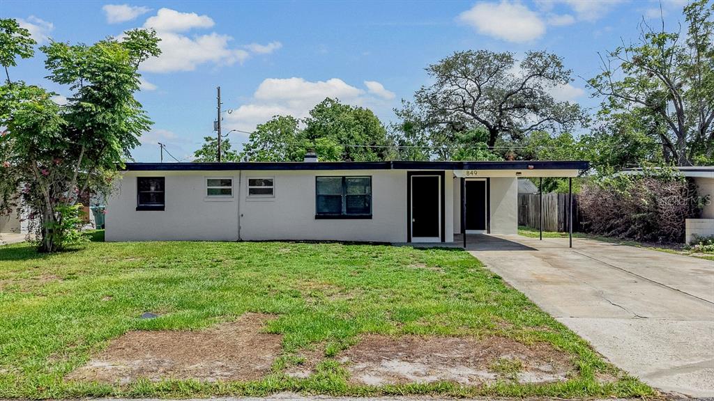 A single-story house with a white exterior, a flat roof, and an attached carport — 849 LOGAN DRIVE, LONGWOOD, FL