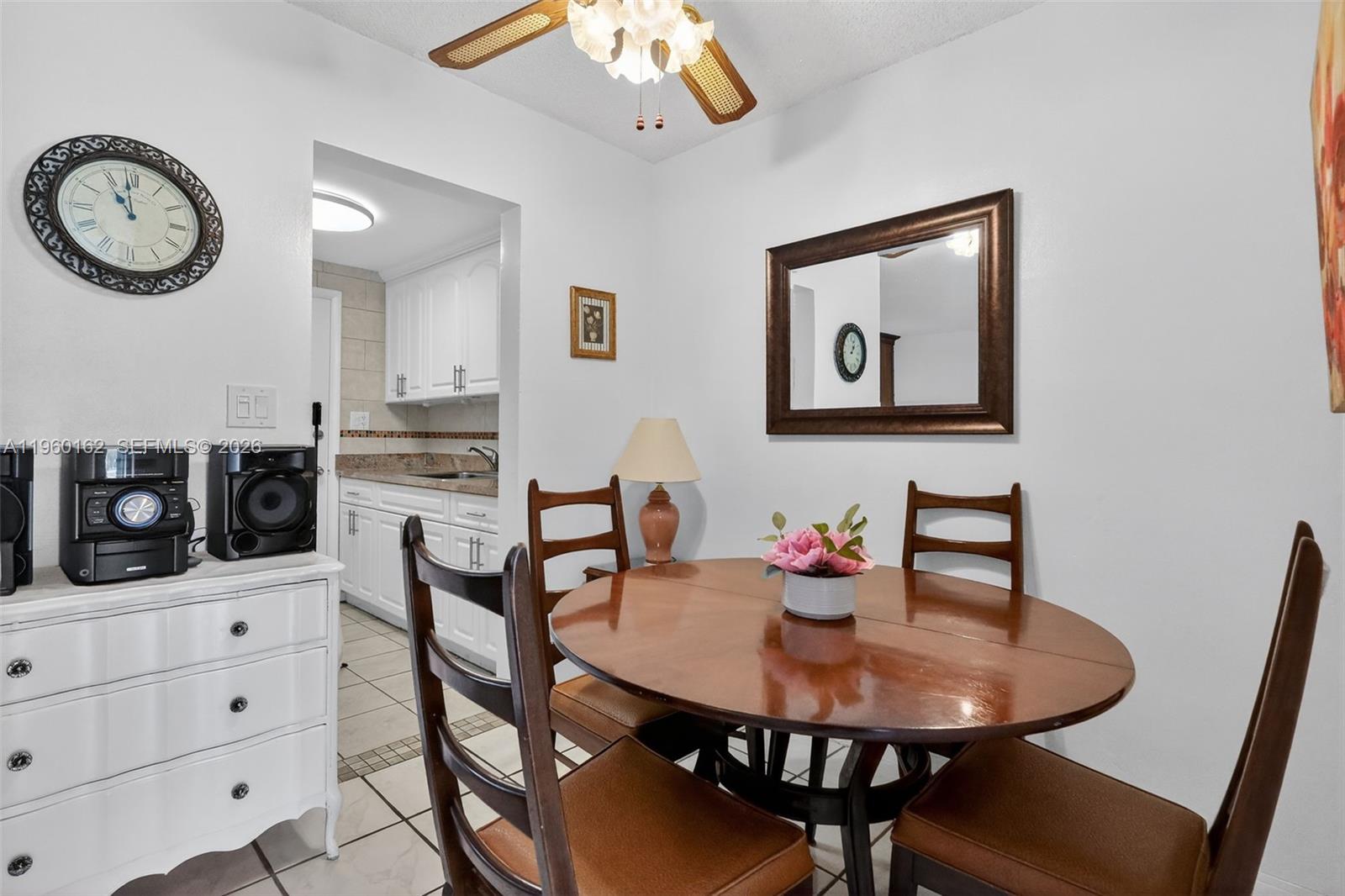 A dining area with a round wooden table, four chairs, and a view into a kitchen — 16901 NE 13th Ave # 108, Miami FL 33162, MIAMI, FL