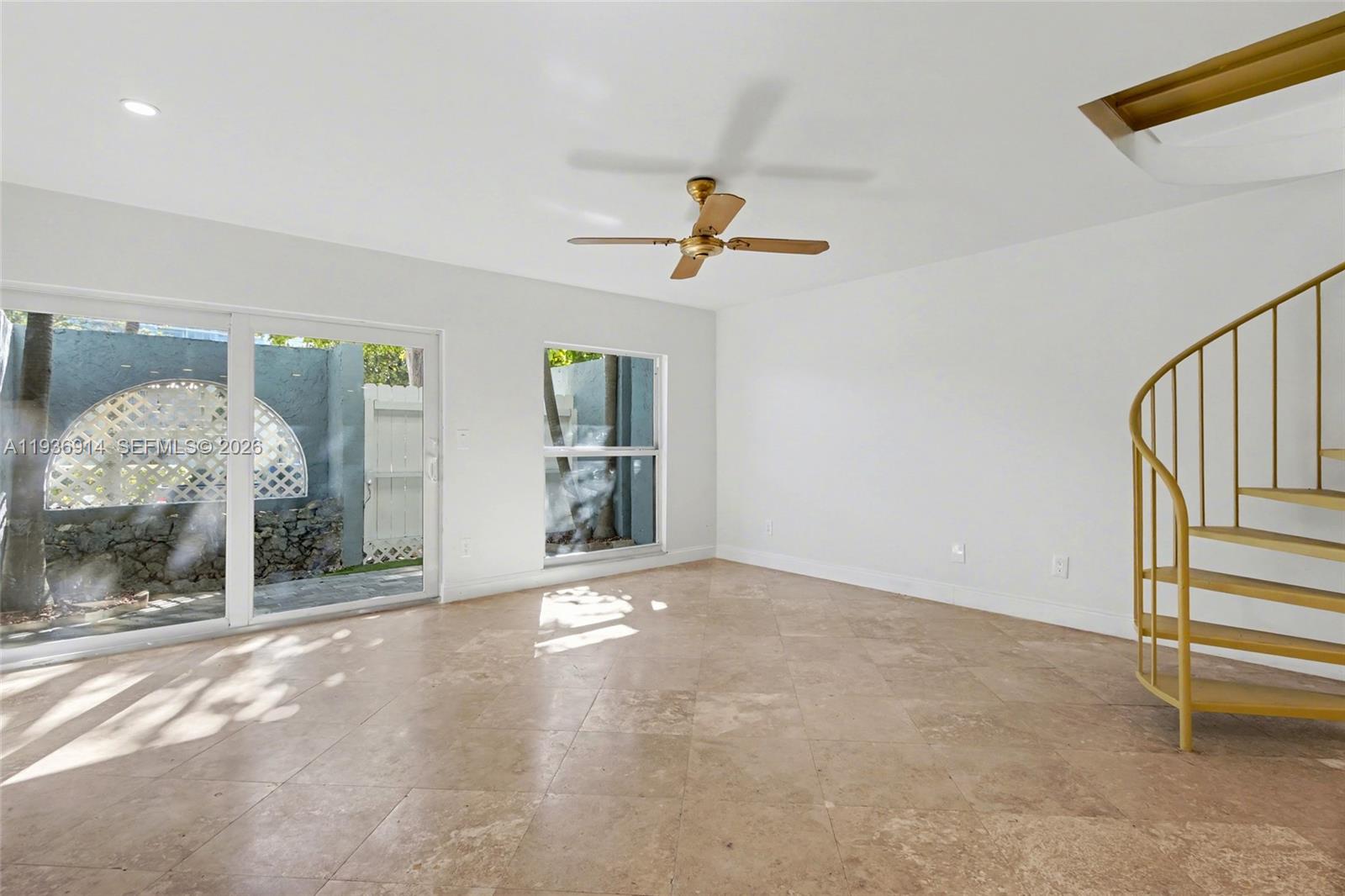 A room with tile floors, a spiral staircase, and a sliding glass door to a patio — 523 NE 38th St # 6, Miami FL 33137, MIAMI, FL