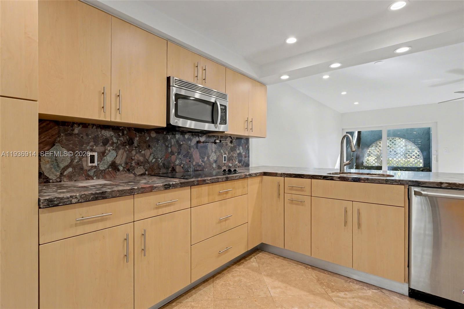 A kitchen features light wood cabinets, dark granite countertops, and stainless steel appliances — 523 NE 38th St # 6, Miami FL 33137, MIAMI, FL