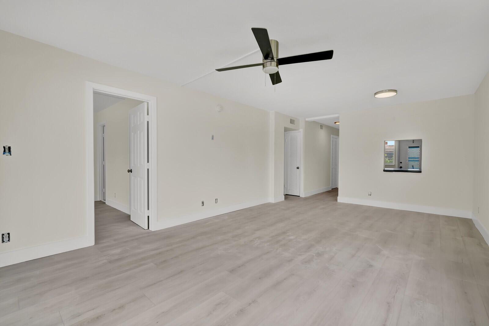 An empty room with light wood-look flooring, white walls, and a ceiling fan — 3201 NE 8th Street # 206, Pompano Beach FL 33062, POMPANO BEACH, FL