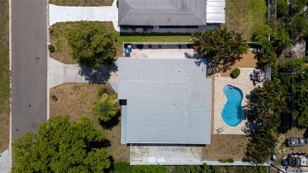 An aerial view shows a house with a gray roof, a pool, and surrounding landscaping — 14480 120TH AVENUE, LARGO, FL