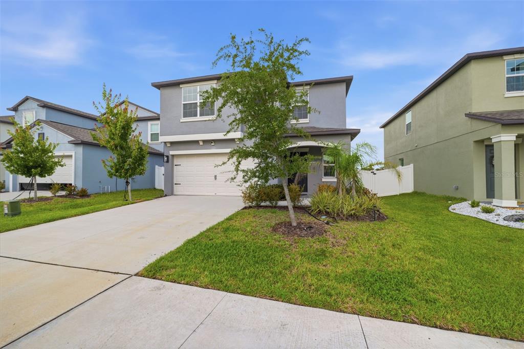 A two-story gray house with a two-car garage and a front lawn — 6453 BACK FORTY LOOP, ZEPHYRHILLS, FL