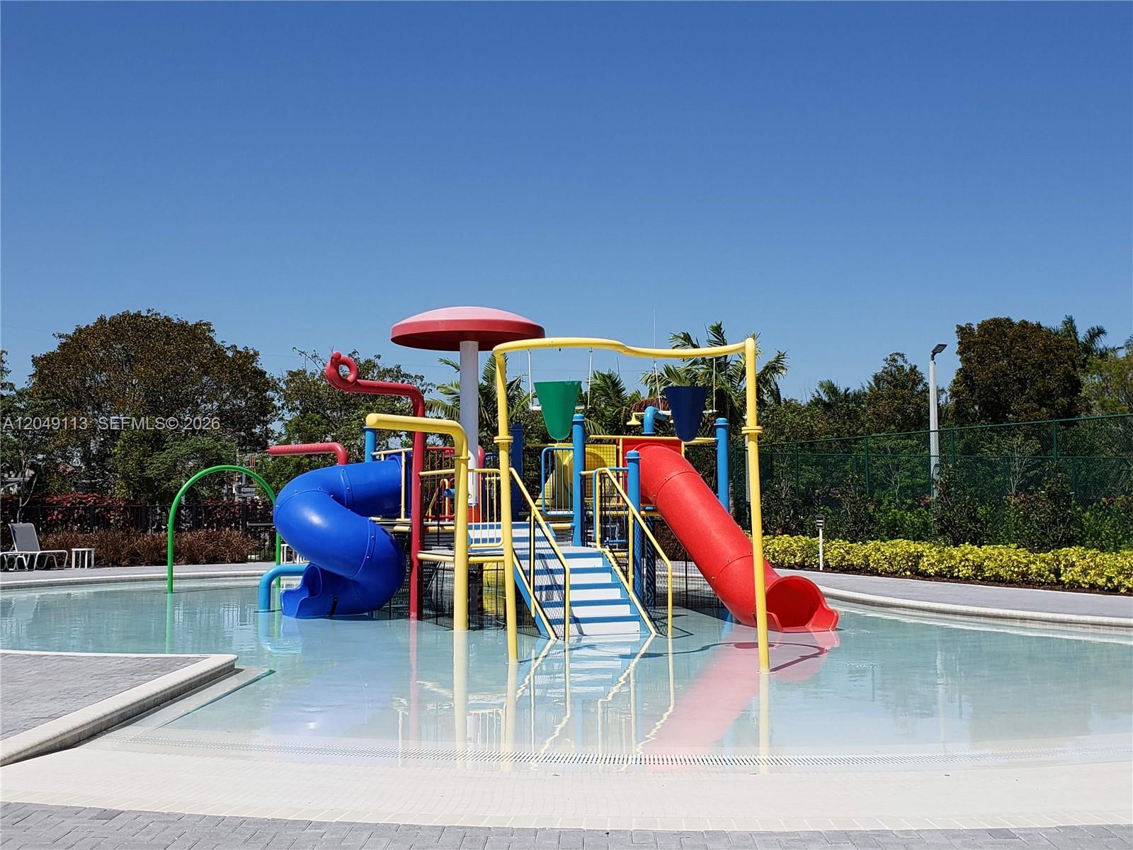 A colorful children's water playground with slides and a mushroom feature sits in a pool — 10620 NW 88th St # 223, Doral FL 33178, DORAL, FL