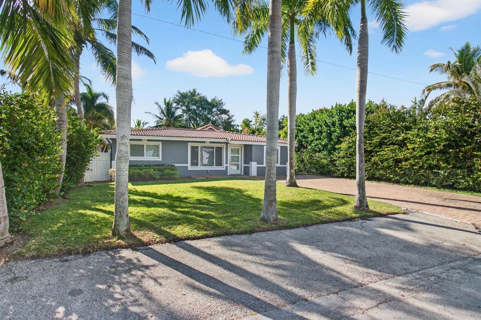 A single-story gray house with a tiled roof sits behind a lawn and palm trees — 360 SW 2nd Street, Boca Raton FL 33432, BOCA RATON, FL