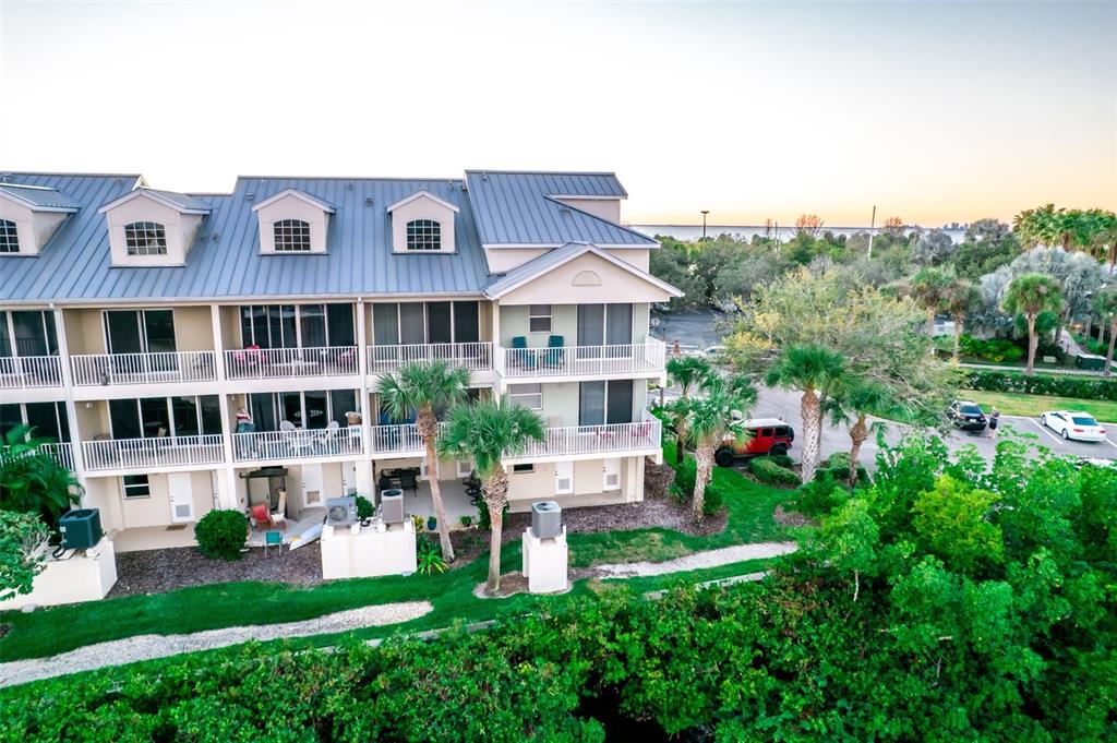 An exterior view of a multi-story residential building with balconies and a metal roof — 465 BAHIA BEACH BOULEVARD, RUSKIN, FL