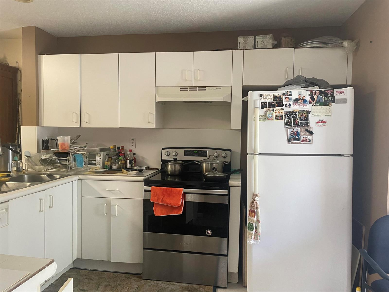 A kitchen features white cabinets, a stainless steel stove, and a white refrigerator — 804 Summit Lake Drive, West Palm Beach FL 33406, WEST PALM BEACH, FL