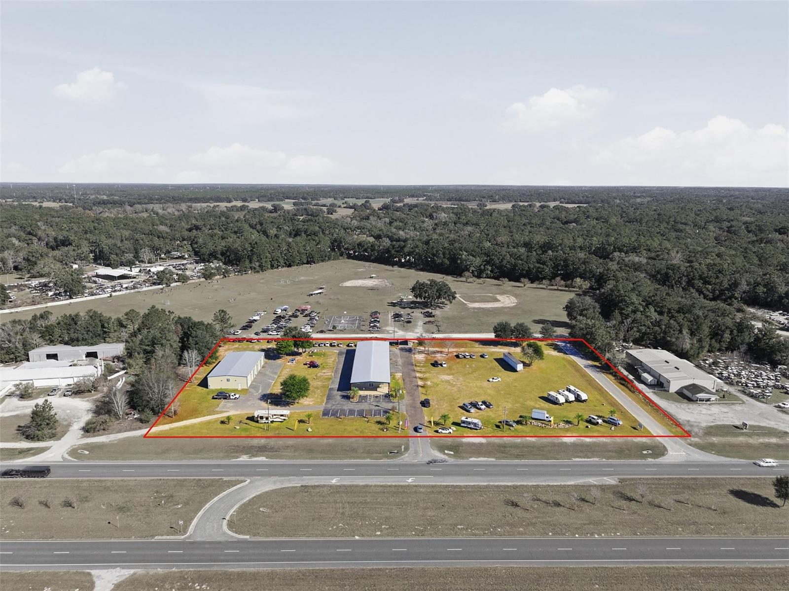 An aerial view shows a rectangular property with two metal buildings and several parked vehicles — 20761 US Highway 27, Williston FL 32696, WILLISTON, FL