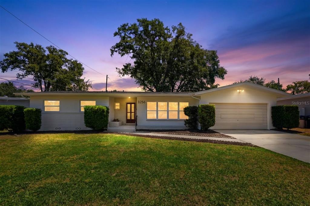 A single-story ranch house with a white exterior, a two-car garage, and a front lawn — 3256 WICKERSHAM COURT, ORLANDO, FL