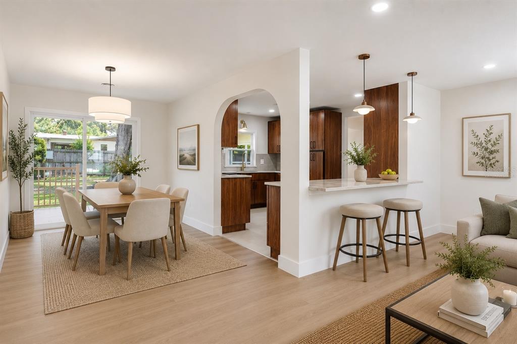 A dining area and kitchen with wood cabinets, an arched doorway, and a breakfast bar — 3256 WICKERSHAM COURT, ORLANDO, FL
