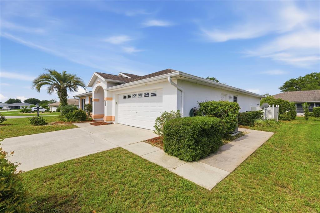 A white single-story house with a two-car garage and a concrete driveway — 8490 SW 60TH COURT, OCALA, FL
