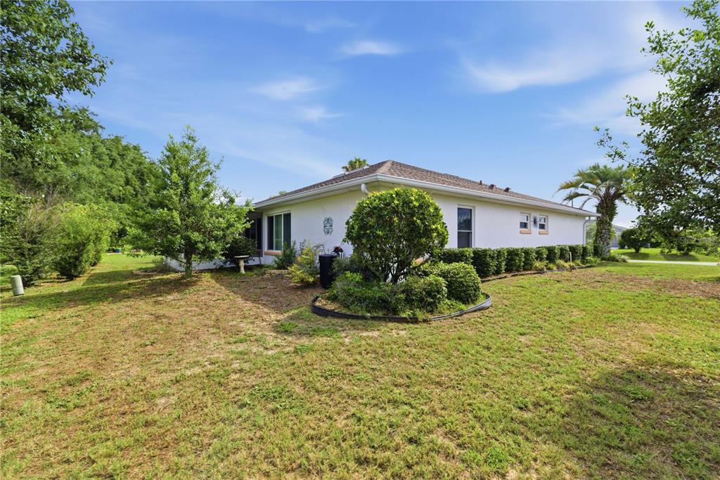 A white single-story house with a hip roof sits on a grassy lot with landscaping — 8490 SW 60TH COURT, OCALA, FL