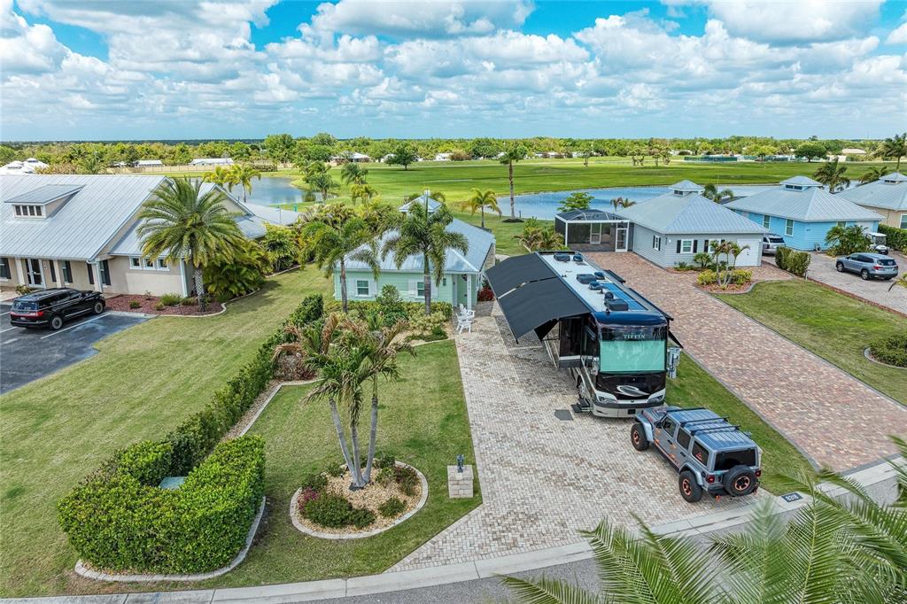 An aerial view shows a house with a large RV parked on a paved driveway — 8318 SW SAND CRANE CIRCLE LOT 86, ARCADIA, FL