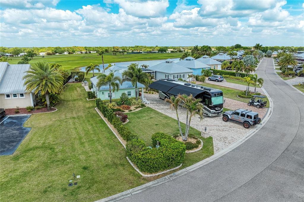 An aerial view shows a light green house with a large RV parked in the driveway — 8318 SW SAND CRANE CIRCLE LOT 86, ARCADIA, FL