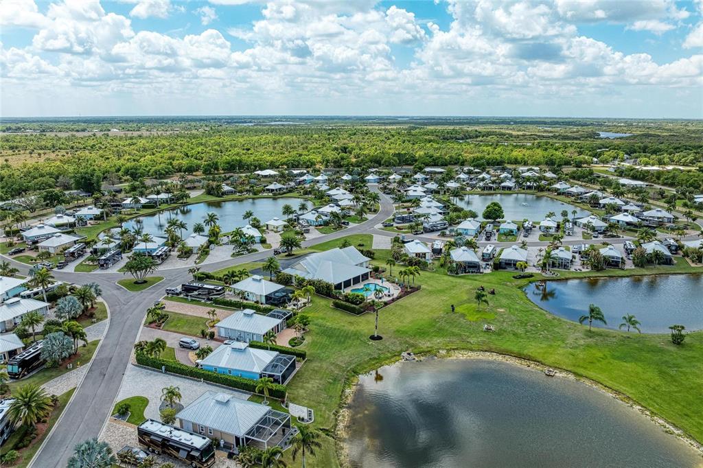 An aerial view of a residential community featuring houses, ponds, and parked recreational vehicles — 8318 SW SAND CRANE CIRCLE LOT 86, ARCADIA, FL