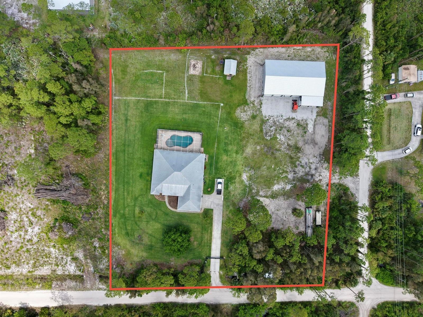 An aerial view shows a house with a pool and a large detached garage — 5224 Southwind Trail, Fort Pierce FL 34951, FORT PIERCE, FL