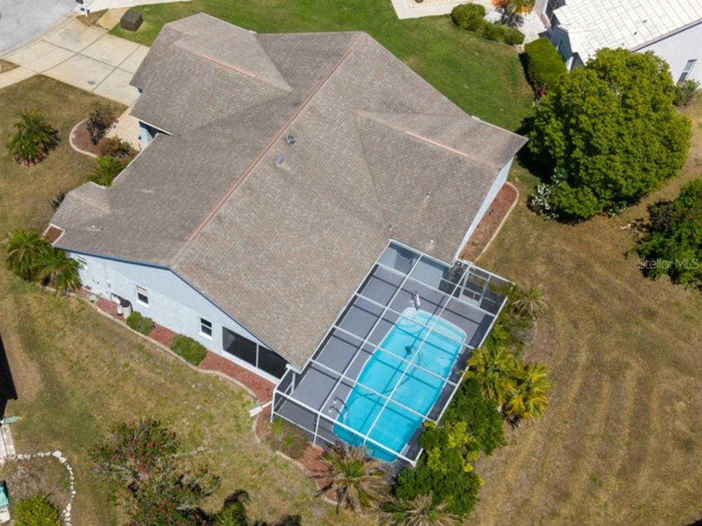 An aerial view shows a house with a screened-in swimming pool in the backyard — 13635 MUFFIN COURT, HUDSON, FL