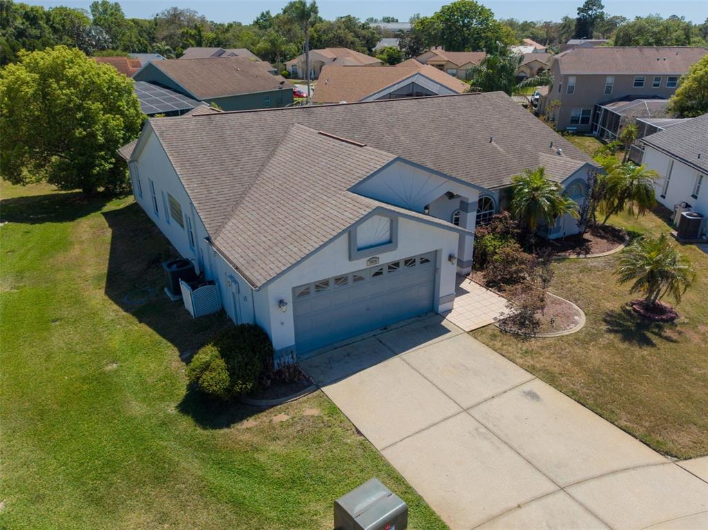 An aerial view of a single-story house with a two-car garage and shingled roof — 13635 MUFFIN COURT, HUDSON, FL