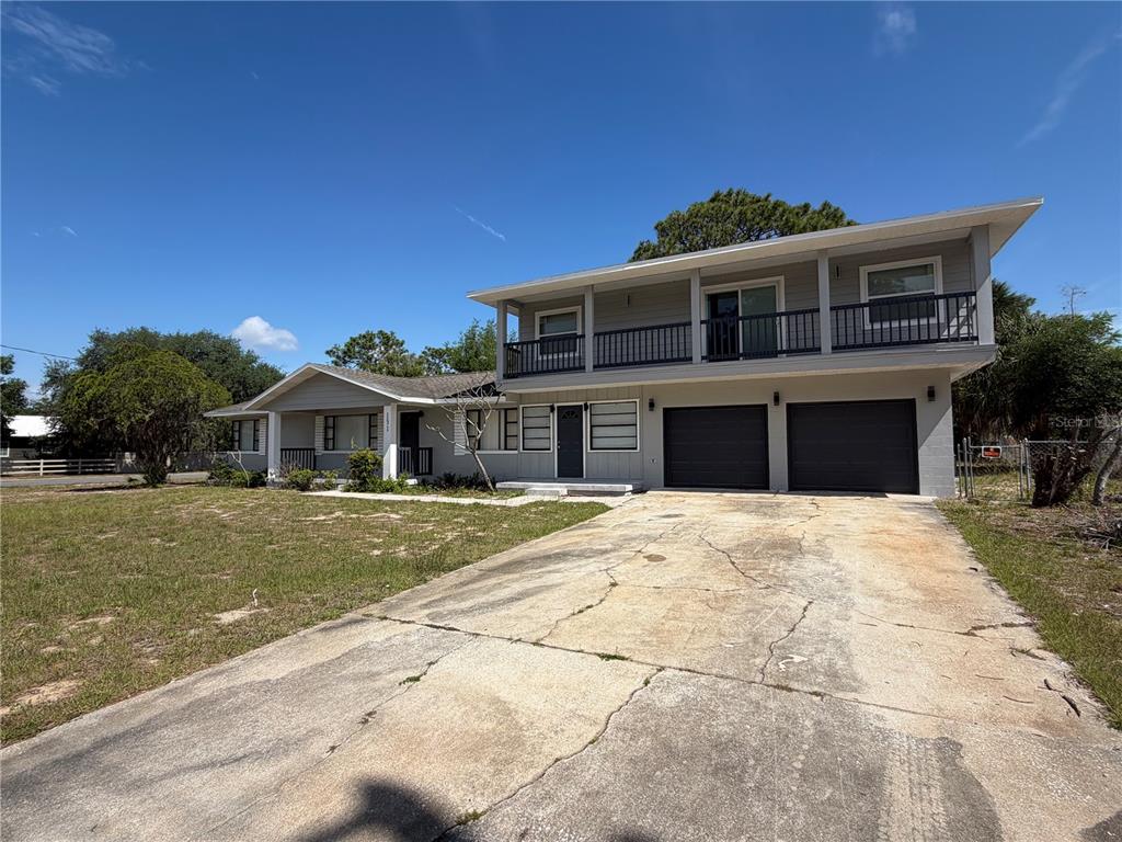 A two-story house with a gray exterior, a balcony, and a two-car garage — 131 W ATWATER AVENUE, EUSTIS, FL