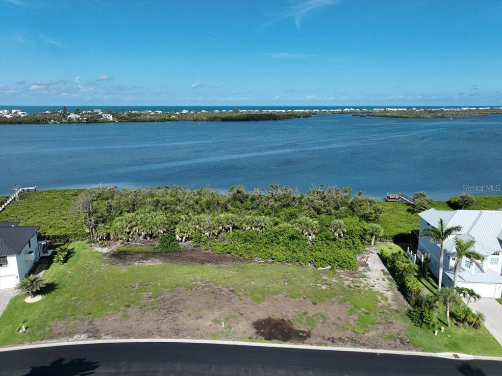 An aerial view of a vacant waterfront lot bordered by residential homes and vegetation — 10011 EAGLE PRESERVE DRIVE, ENGLEWOOD, FL