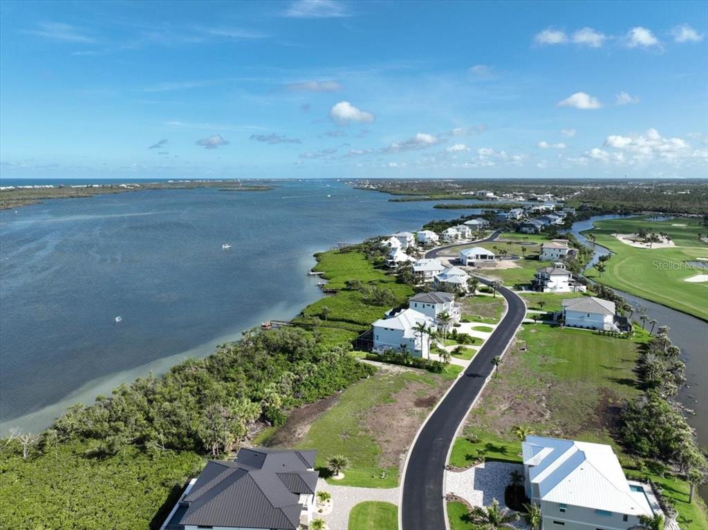An aerial view shows waterfront houses along a road next to a golf course — 10011 EAGLE PRESERVE DRIVE, ENGLEWOOD, FL