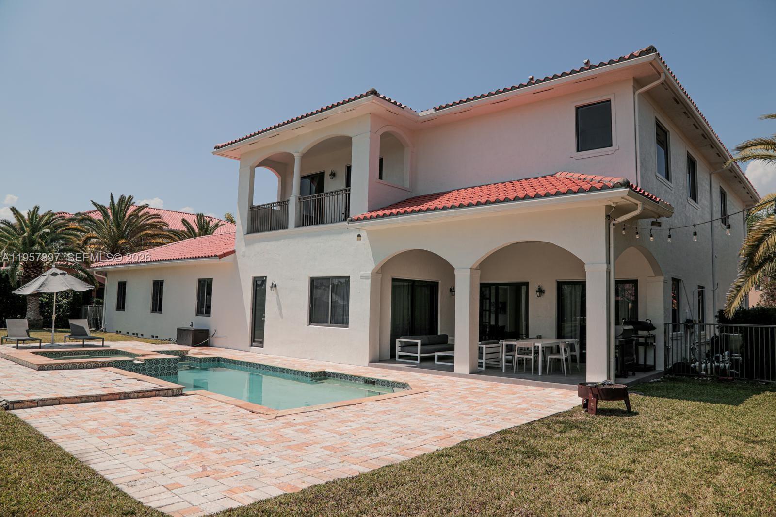 A two-story house with a tiled roof, covered patio, and a swimming pool in the backyard — 19209 SW 80th Ct, Cutler Bay FL 33157, CUTLER BAY, FL
