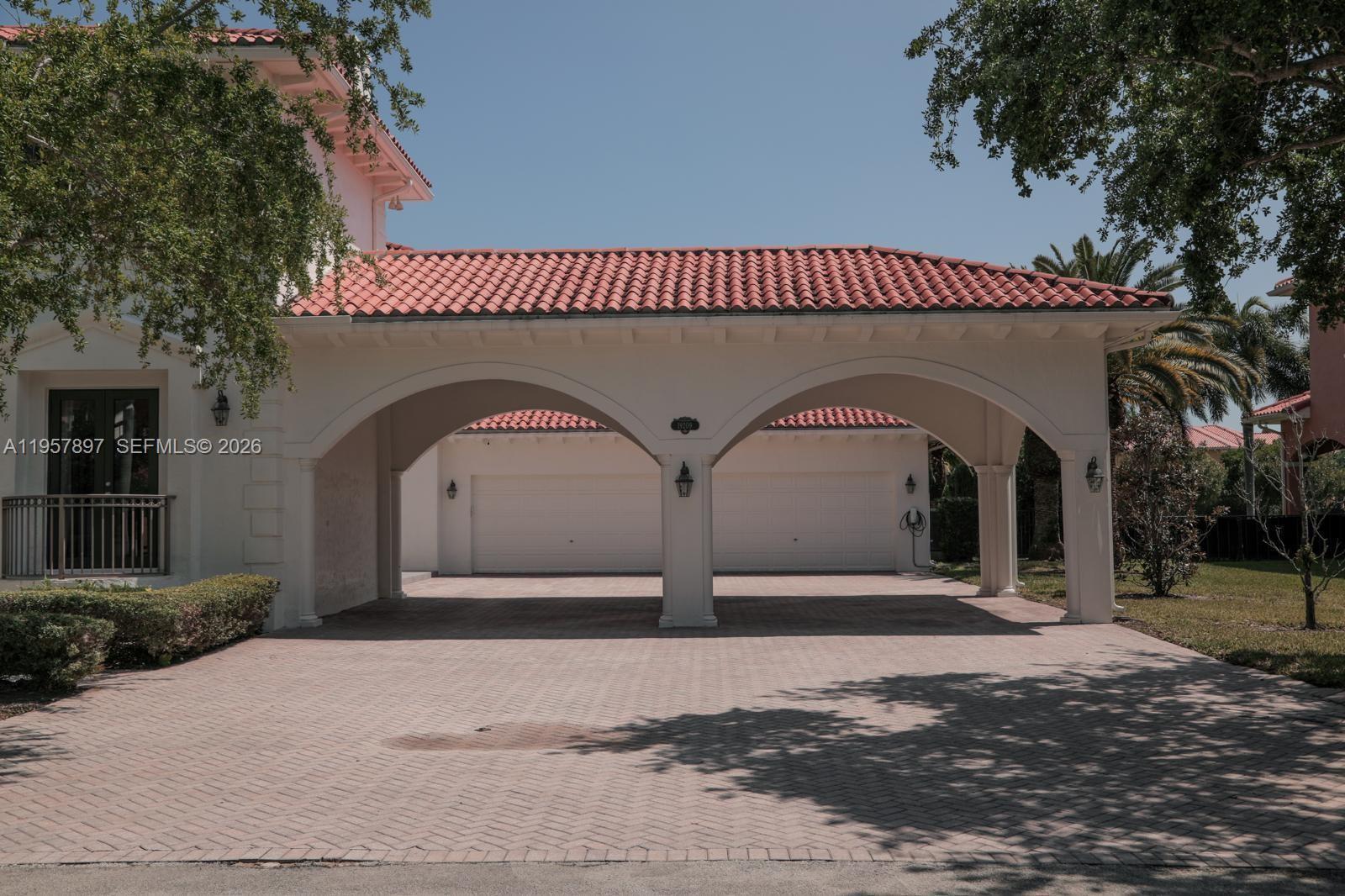 A white house features a large arched porte-cochère leading to a two-car garage — 19209 SW 80th Ct, Cutler Bay FL 33157, CUTLER BAY, FL