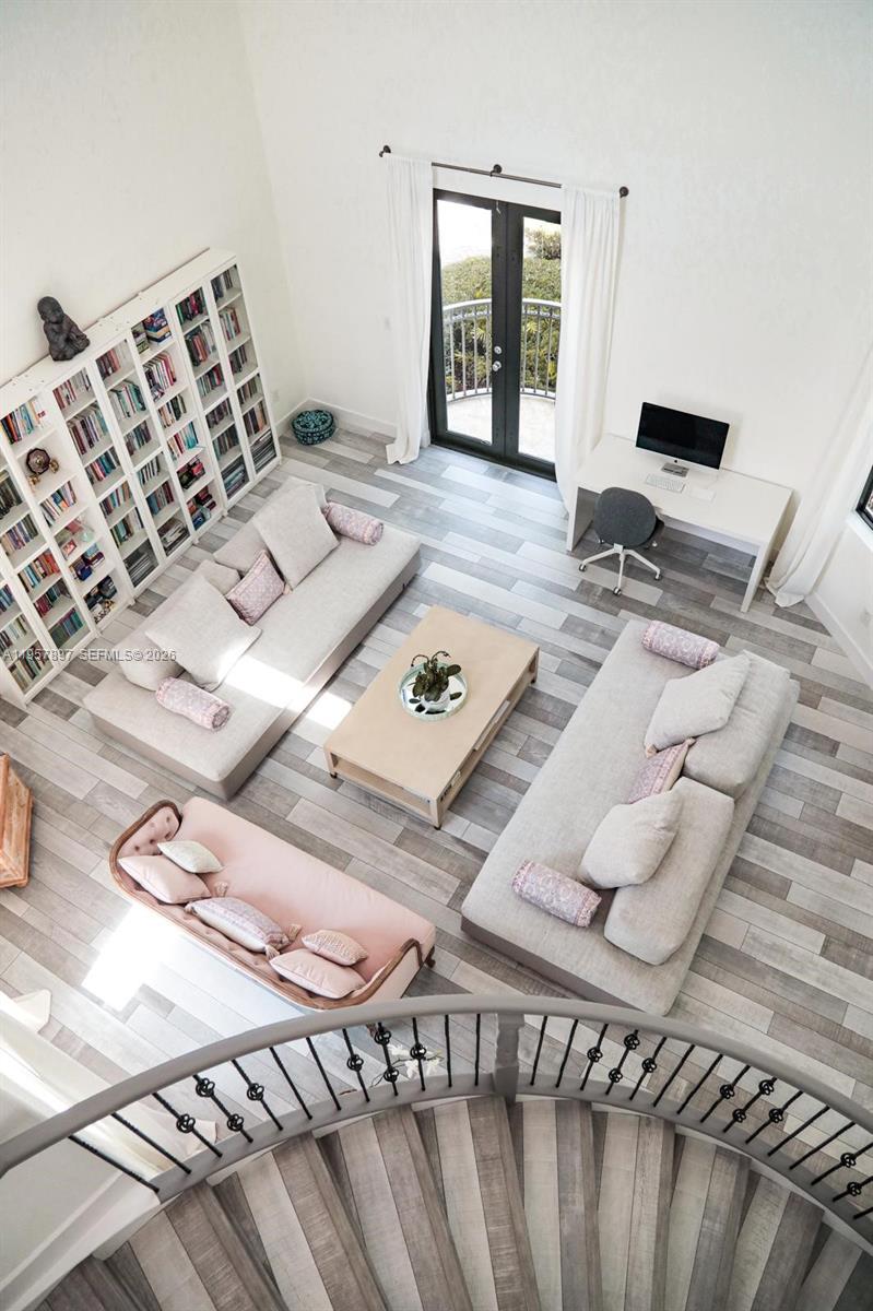 A high-angle view of a living room with light wood floors, two sofas, and bookshelves — 19209 SW 80th Ct, Cutler Bay FL 33157, CUTLER BAY, FL