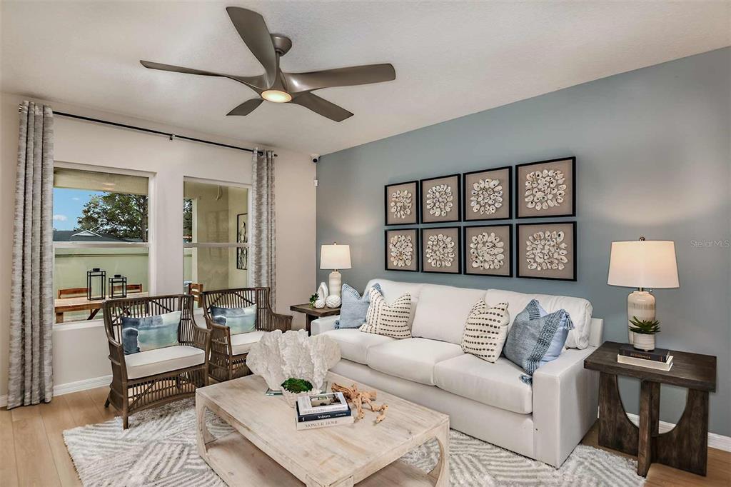A living room features a white sofa, two rattan chairs, and a blue accent wall — 4254 HILLOCK BOULEVARD, HAINES CITY, FL
