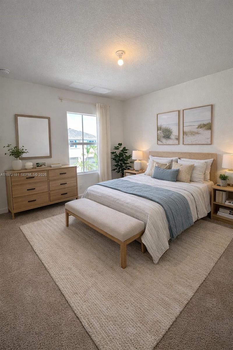 A bedroom features a bed with a blue runner, a wooden dresser, and a rug — 1765 SE 7th Ter, Homestead FL 33034, HOMESTEAD, FL