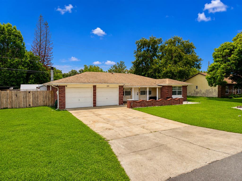 A single-story brick house with a two-car garage and a concrete driveway — 1594 FRANCES STREET, KISSIMMEE, FL