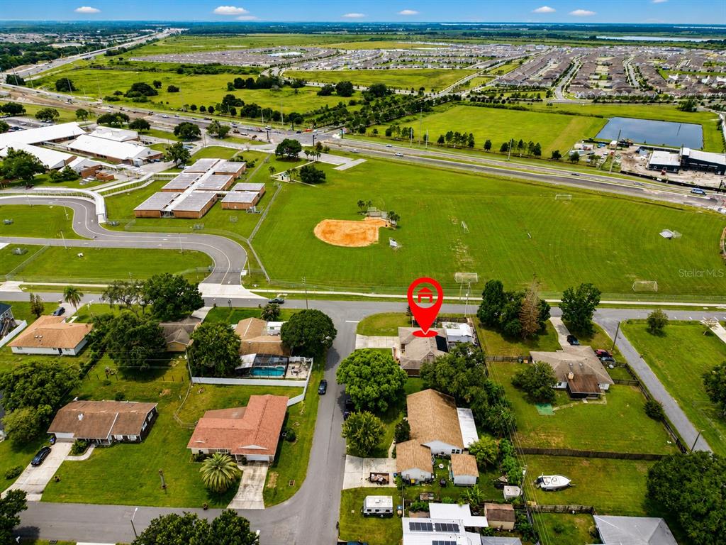 An aerial view shows a residential neighborhood with a red location pin over a house — 1594 FRANCES STREET, KISSIMMEE, FL