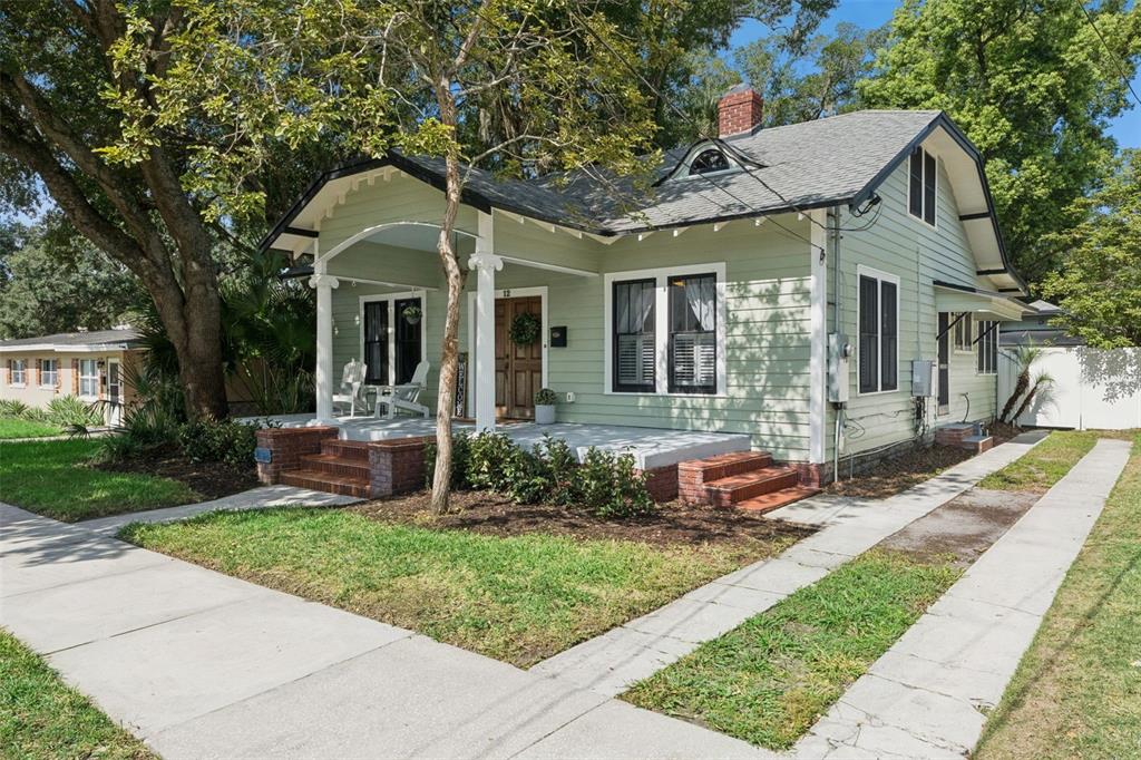 A light green bungalow with a covered front porch, brick steps, and a shingled roof — 12 N THORNTON AVENUE, ORLANDO, FL