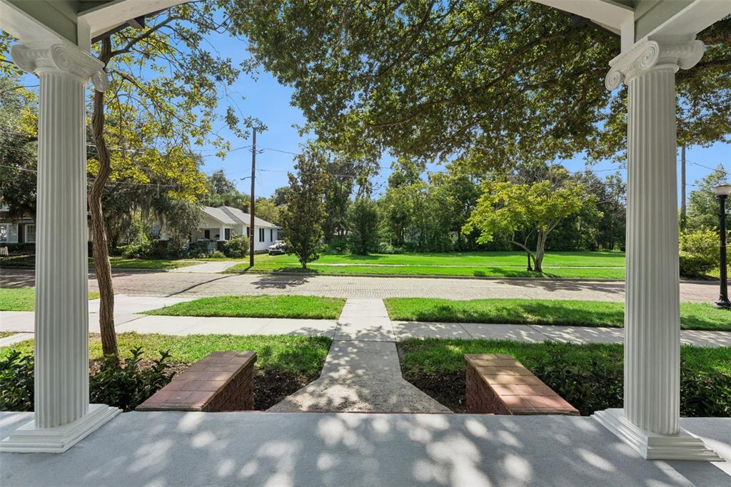 A view from a covered porch with white columns looking out toward a residential street — 12 N THORNTON AVENUE, ORLANDO, FL
