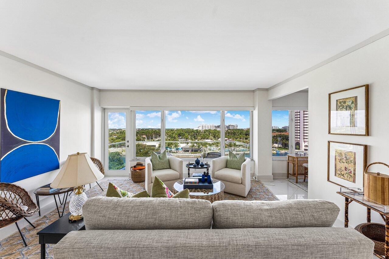 A living room features a gray sofa, two armchairs, large windows, and a water view — 701 E Camino Real Apt 9g, Boca Raton FL 33432, BOCA RATON, FL
