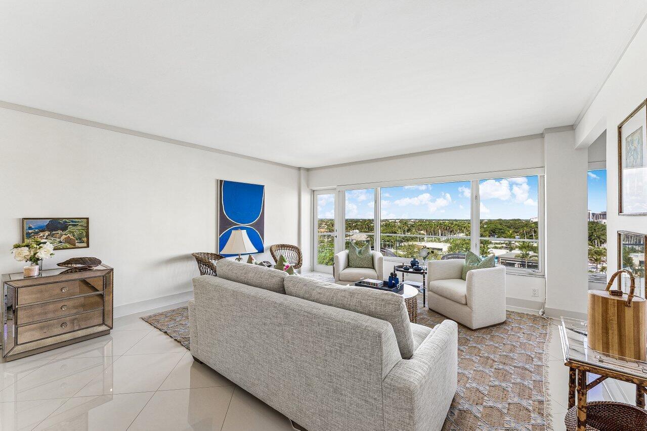 A bright living room features a gray sofa, two armchairs, and floor-to-ceiling windows with views — 701 E Camino Real Apt 9g, Boca Raton FL 33432, BOCA RATON, FL