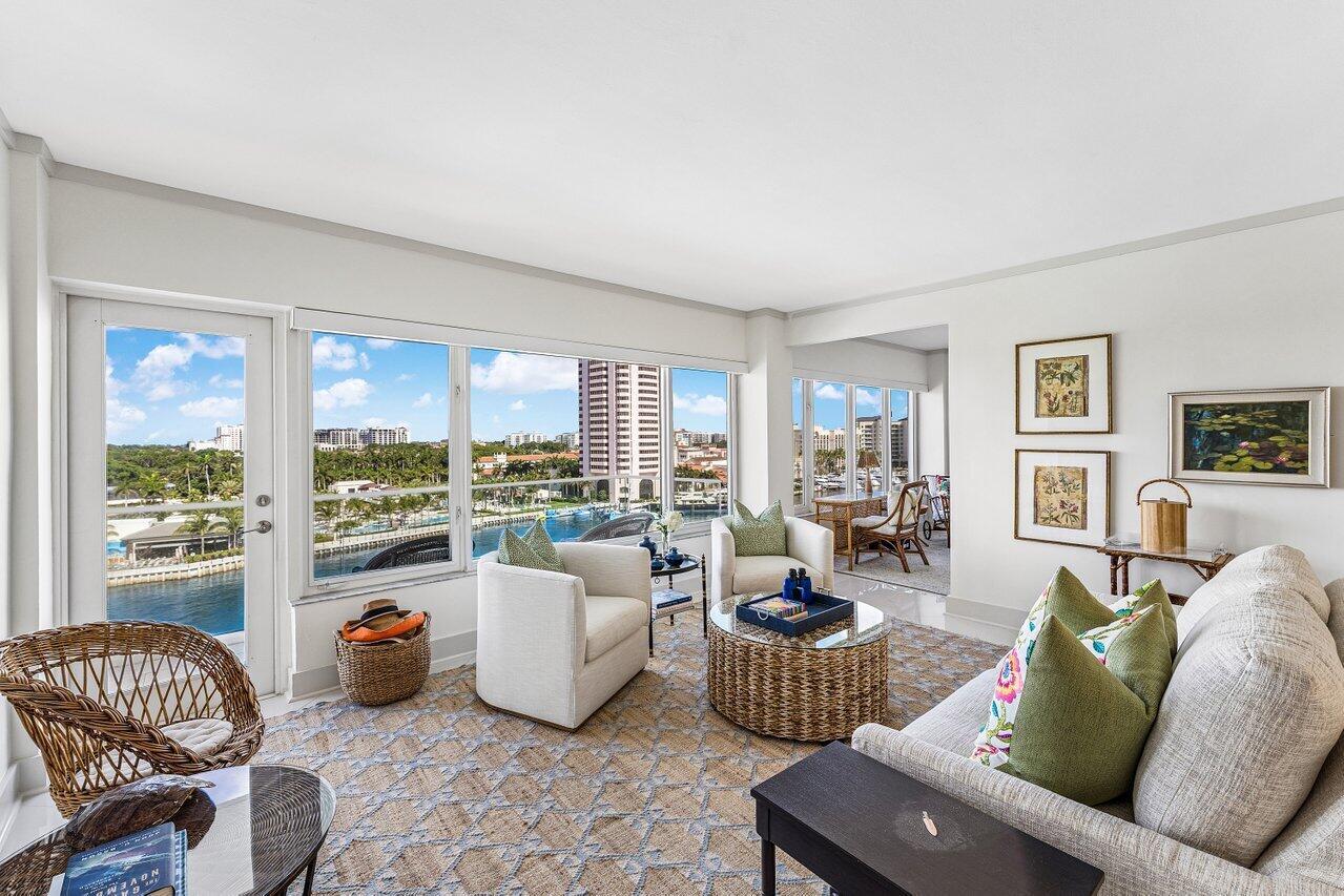 A bright living room features a water view, wicker furniture, and a neutral color palette — 701 E Camino Real Apt 9g, Boca Raton FL 33432, BOCA RATON, FL