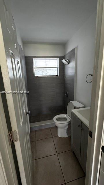 A bathroom features a walk-in shower with gray tile, a toilet, and a vanity cabinet — FORT LAUDERDALE, FL