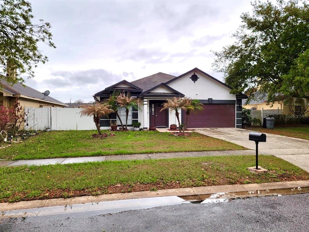 A single-story house with a white exterior, dark trim, and a two-car garage — 1946 EXCALIBUR DRIVE, ORLANDO, FL
