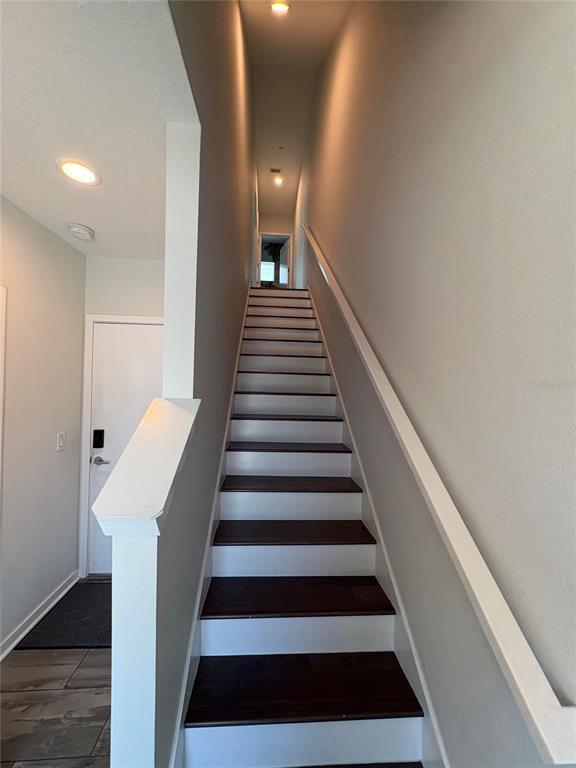 A staircase with dark wood treads and white risers leads to an upper level — 343 8TH STREET N, ST PETERSBURG, FL