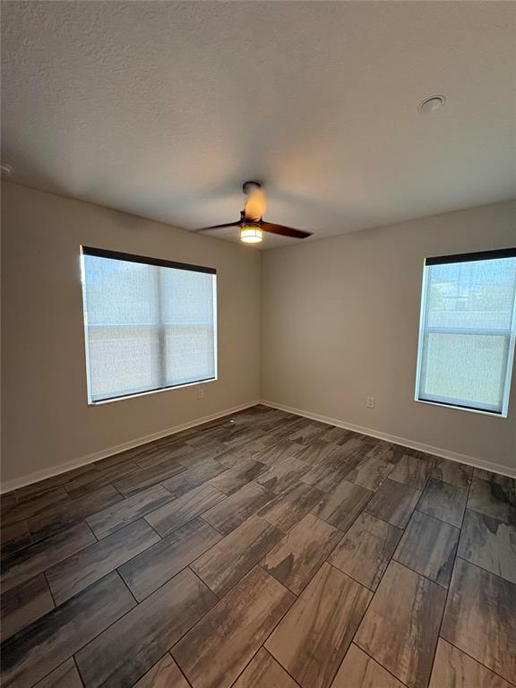 An empty bedroom features light-colored walls, a ceiling fan, and wood-look tile flooring — 343 8TH STREET N, ST PETERSBURG, FL