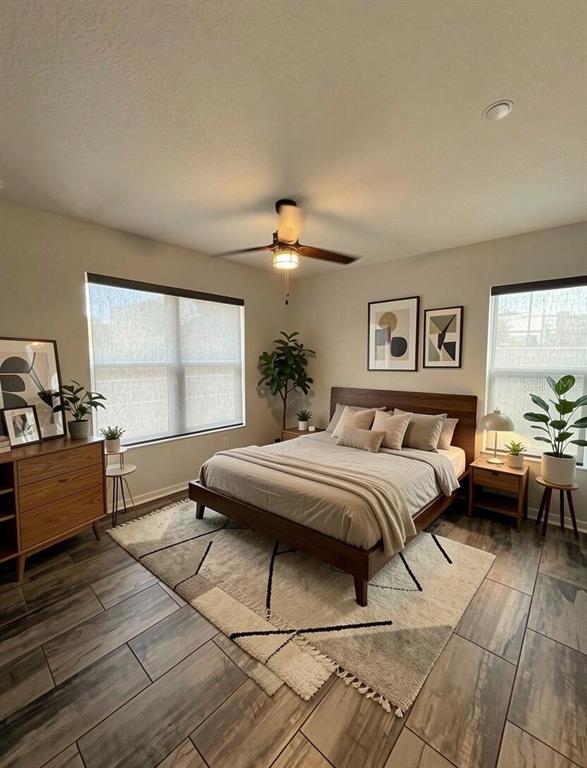 A bedroom features a wooden bed frame, a patterned area rug, and tile flooring — 343 8TH STREET N, ST PETERSBURG, FL
