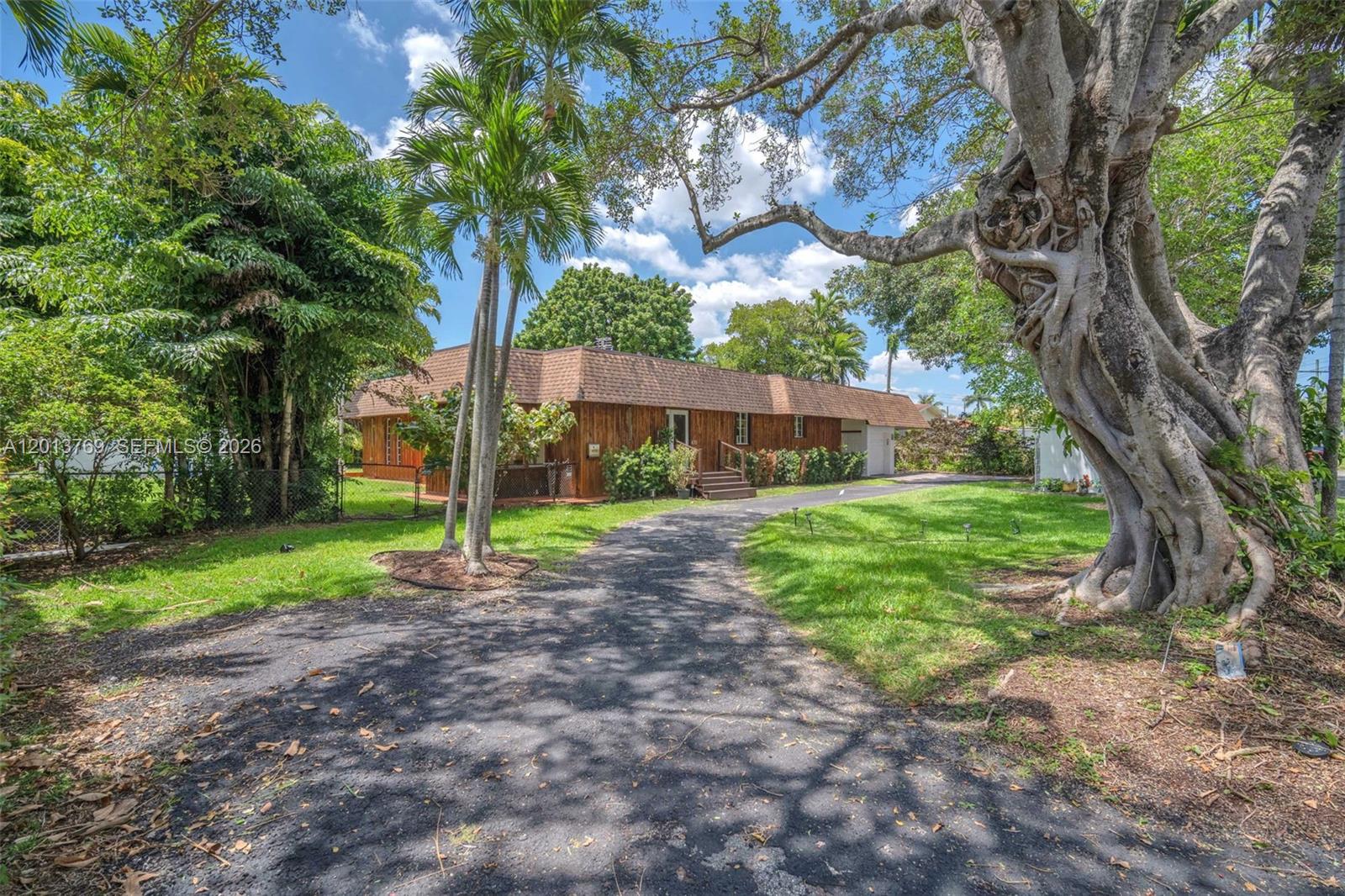 A single-story house with wood siding and a brown shingled roof sits behind a driveway — 470 NE 113th St # 1, Miami FL 33161, MIAMI, FL