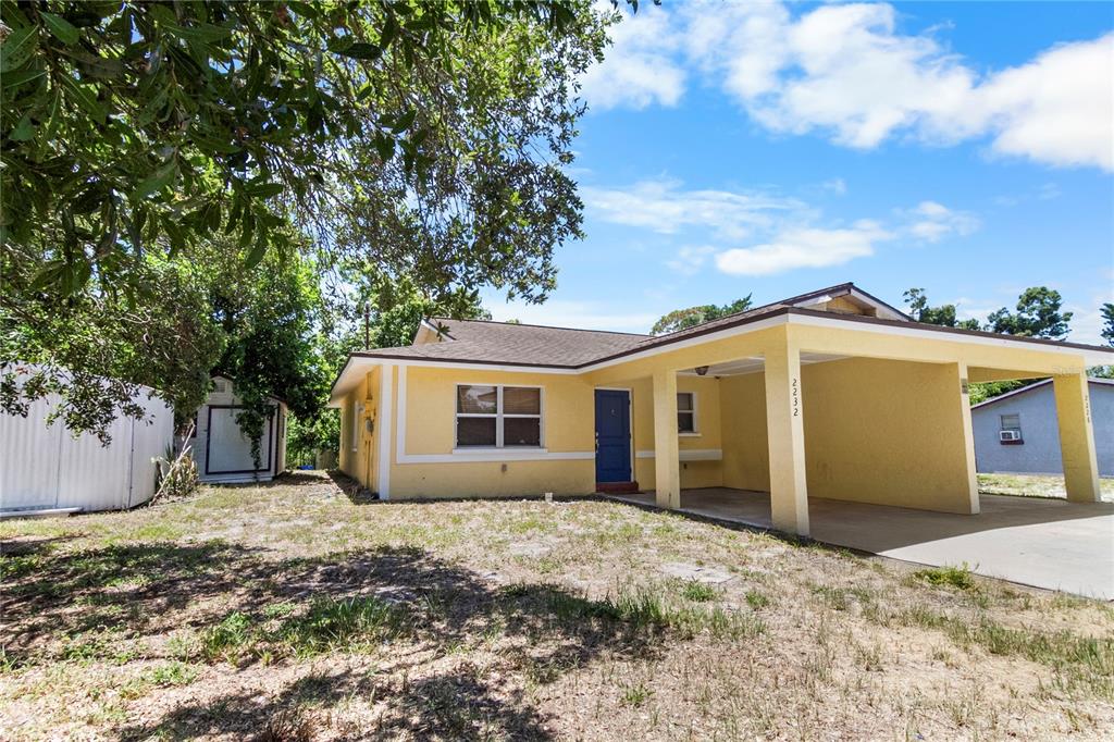 A yellow single-story house with a blue front door and an attached carport — 2228 25TH STREET UNIT 2228/2232, SARASOTA, FL