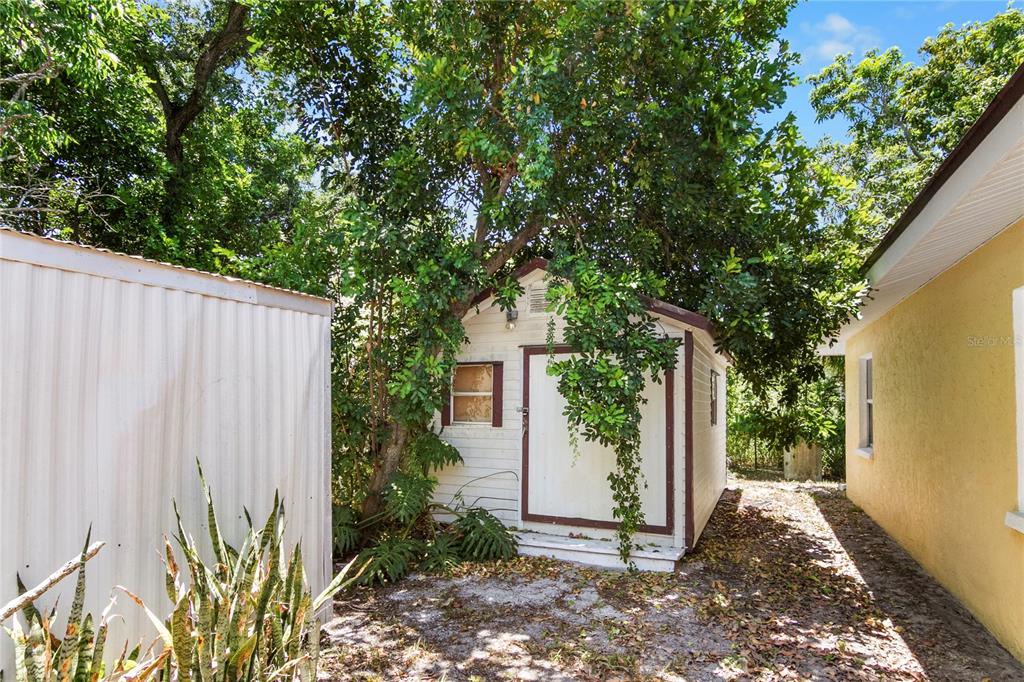 A small white shed sits between a metal storage unit and a yellow house exterior — 2228 25TH STREET UNIT 2228/2232, SARASOTA, FL