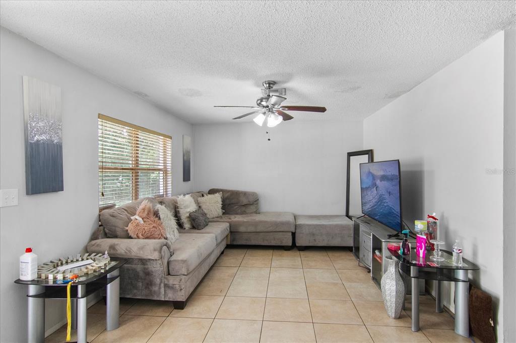 A living room features a grey sectional sofa, a television on a stand, and tile flooring — 2228 25TH STREET UNIT 2228/2232, SARASOTA, FL