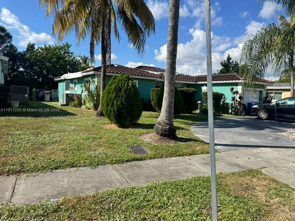 A teal single-story house with a tiled roof and palm trees in the front yard — 820 SW 49th Ter, Margate FL 33068, MARGATE, FL