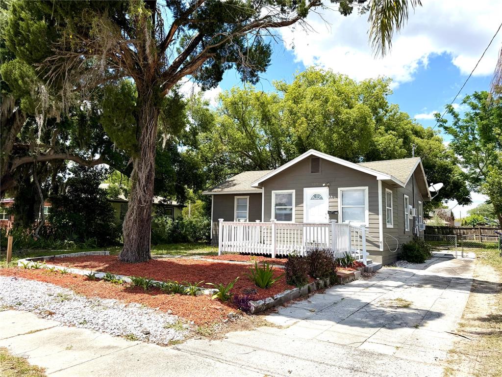 A single-story house with gray siding, a white front deck, and a large tree nearby — 139 AVENUE G SE, WINTER HAVEN, FL